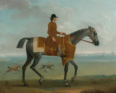 A Grey Racehorse With A Jockey Up Exercising On Newmarket Heath