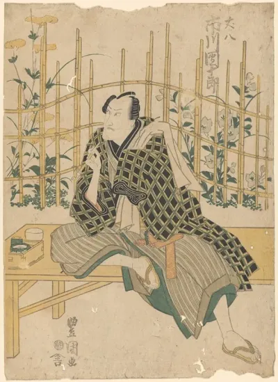 Actor On Bench Flowers And Bamboo In Background