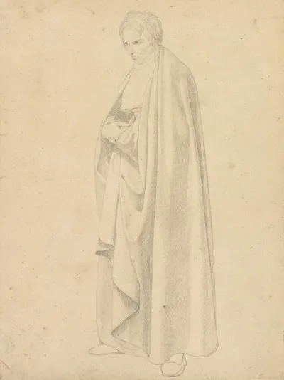 Joseph Wintergerst In A Floor Length Coat Standing With His Hands Placed On Top Of One Another