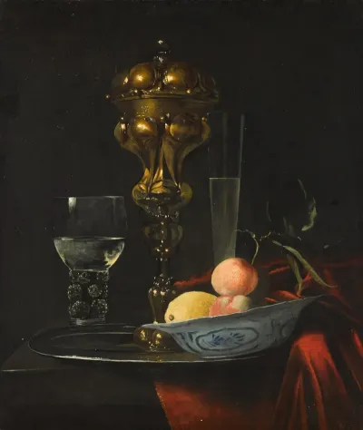 Still Life With A Gilt Cup On A Silver Plate A Porcelain Bowl With Fruit A Roemer And A Wine Glass All On A Wooden Table Draped In Red Fabric