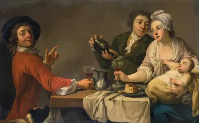 Two Young Men And A Woman Holding A Child Seated At A Table Drinking Wine