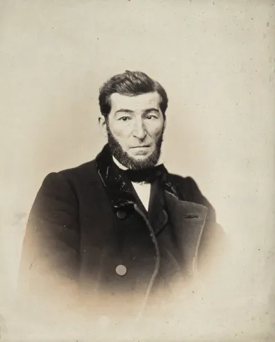 A bearded man, head and shoulders; his left eye points inwards, while his right eye points straight ahead