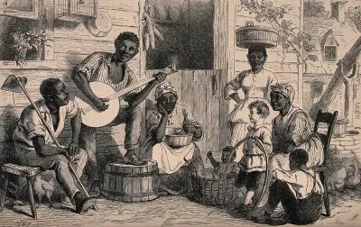 A black family sit outside a house listening to a man play on a banjo, attended by a white boy holding a hoop