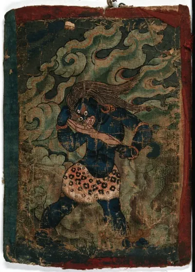 A blue Tibetan demon about to eat a human body stretched between his hands