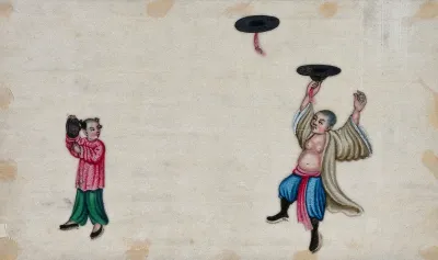 A Chinese entertainer spinning hats in the air with the assistance of a girl