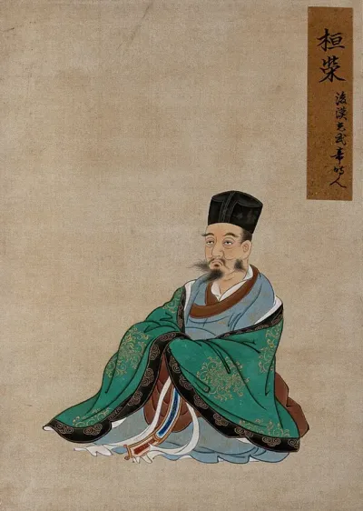 A Chinese figure, seated, wearing green robes with black border and black hat