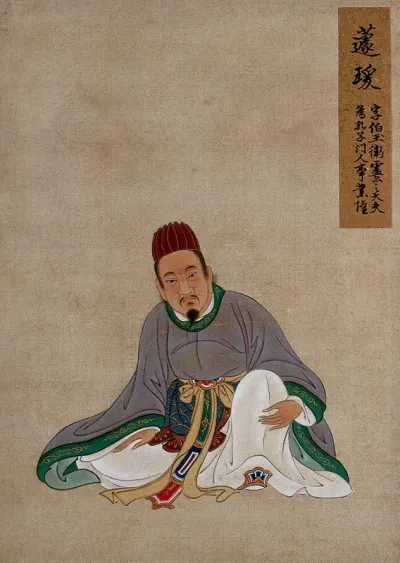 A Chinese figure, seated, wearing pale mauve robes with green border and brown hat