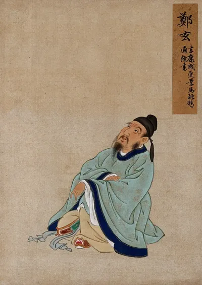 A Chinese figure, seated wearing pale turquoise coloured silk robes with an indigo border and buff undergarments