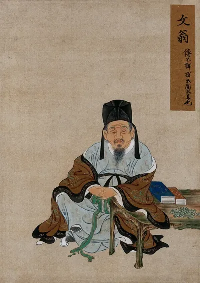 A Chinese figure, seated, with arm resting on a table with books; wearing brown and pale blue robes and tall black hat