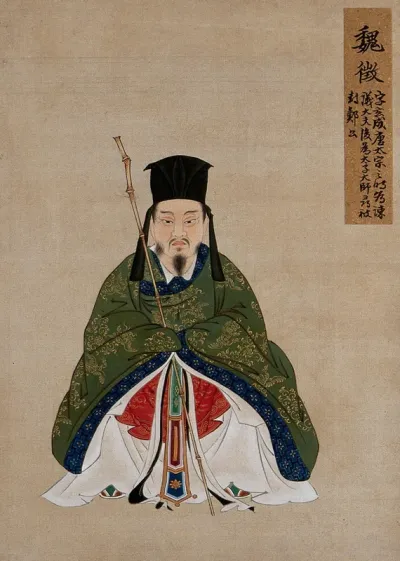 A Chinese figure, seated, with bamboo staff,wearing green robes with blue border and black hat
