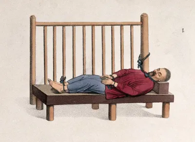 A Chinese man imprisoned with bound hands and feet is reclining on a bench