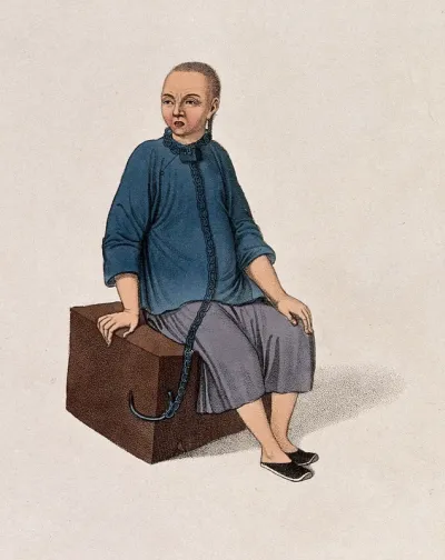 A Chinese man seated on a square block of wood is tied to it with a chain round his neck