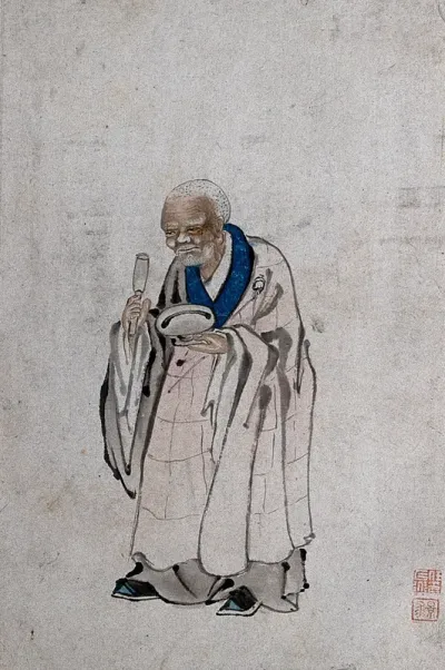 A Chinese man standing, holding a pestle and mortar