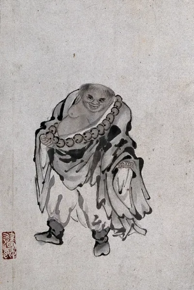 A Chinese man standing, wearing a string of big beads around his chest