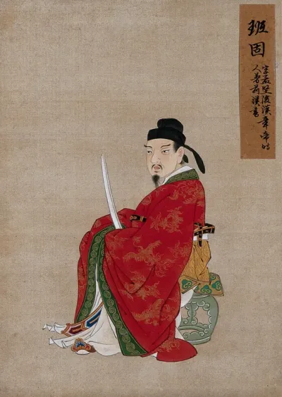 A Chinese seated figure in red silk with green border