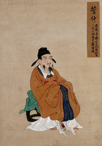A Chinese seated figure with grey beard and black hat