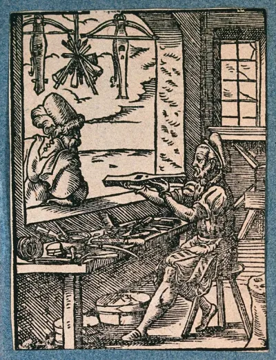 A crossbow maker (bowyer) is working at his workbench, with two finished crossbows and some bolts hanging in the window