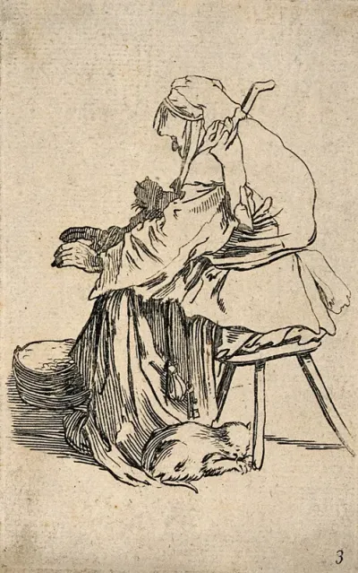 A female beggar sitting on a stool with a cat on her lap and another cat curled up under the stool
