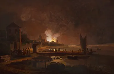 A fire in a town at an inlet.