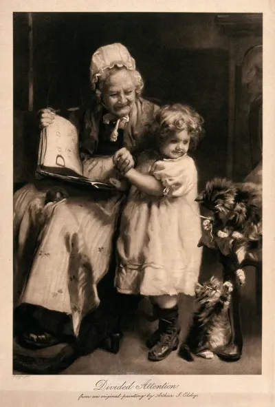 A grandmother reads to her granddaughter, but their attention is caught by two kittens playing with a piece of thread