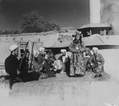 A group of musicians playing for a bacha dancing boy