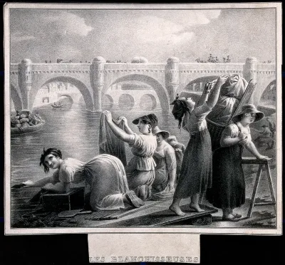 A group of women are washing clothes in the river