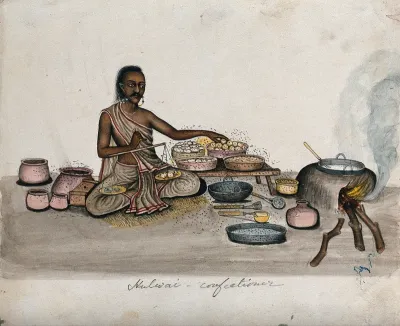 A halwai (sweet maker) weighing some mithai (sweets)