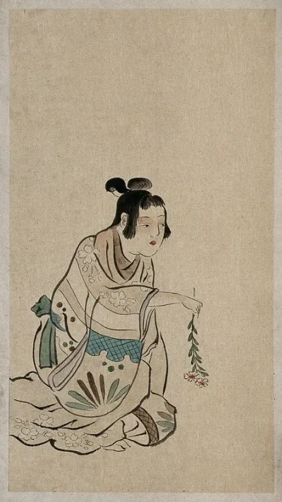A Japanese woman seated and holding a branch of a flower with the flowers downwards