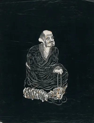 A Lohan (disciple of Buddha), seated on a rock, holding prayer beads