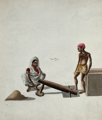 A man and a woman pounding and mixing grains or spices with a foot-operated mortar and pestle