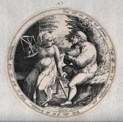 A man and a woman sit in a farmyard, the man has a hen on his knee