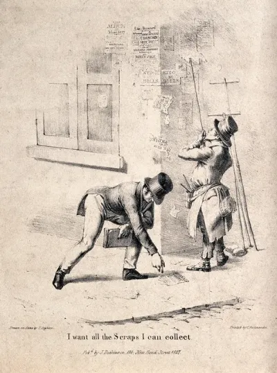 A man bending down in the street to pick up a scrap of a discarded poster that is being blown around by the wind