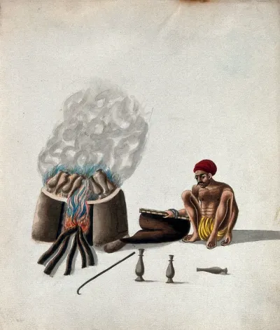 A man firing pots in a wood smoked oven
