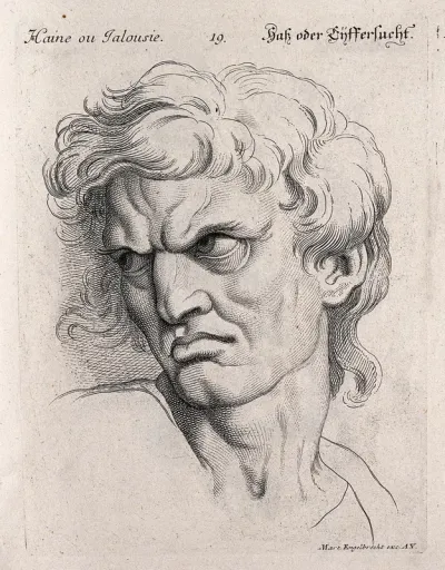 A man glowering, expressing hatred or jealousy