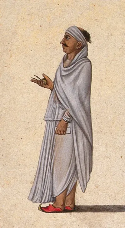 A man holding a ink pot, two pens and a book in his hands