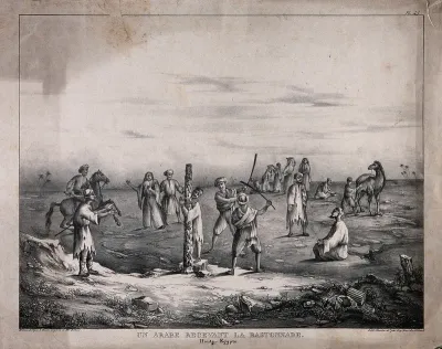 A man in Egypt tied to a stake receives a beating with wooden bats