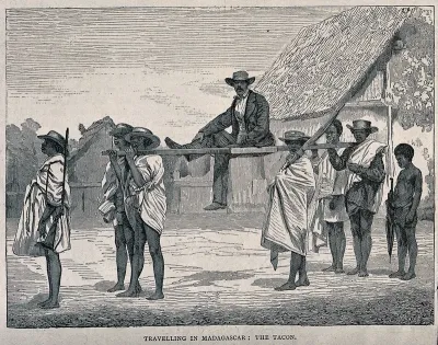 A man in Madagascar being carried on a litter on the shoulders of four men