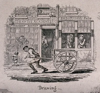 A man is drawing a cart along the road as other people perform other activities also called drawing