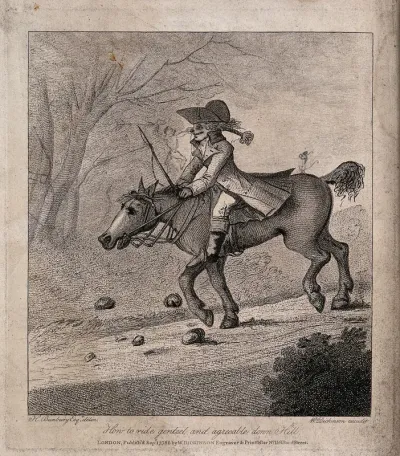 A man is on horseback riding down a hill