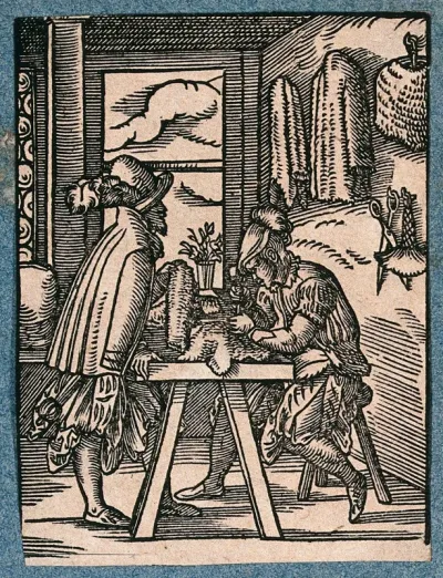 A man is working at a table making chain-mail, greaves and other defensive armour; another man inspects a product