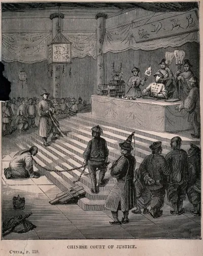 A man kneeling in front of a judge at a Chinese court of justice