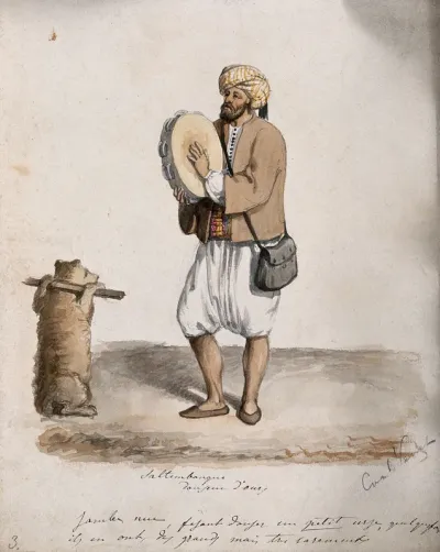 A man plays a tambourine as a bear with its arms held back is encouraged to dance
