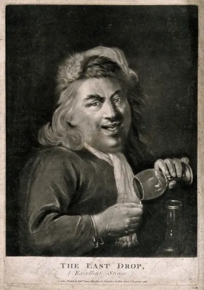 A man pouring the last drop from his wine glass