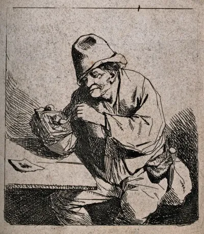 A man sits at a table lighting his pipe