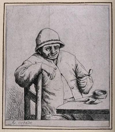 A man sits at a table preparing to smoke his pipe