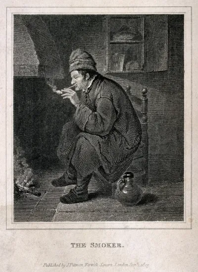 A man sits smoking by a fireplace with a jug on the floor beside him