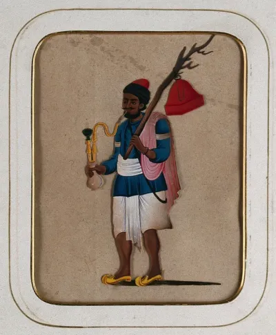 A man smoking a hookah pipe and holding a branch with a red object hanging from it