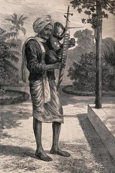 A man standing in a garden in Madras playing the stick zither or tingadee
