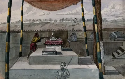 A man tends a Hindu altar on a stepped dais, sheltered by a canopy