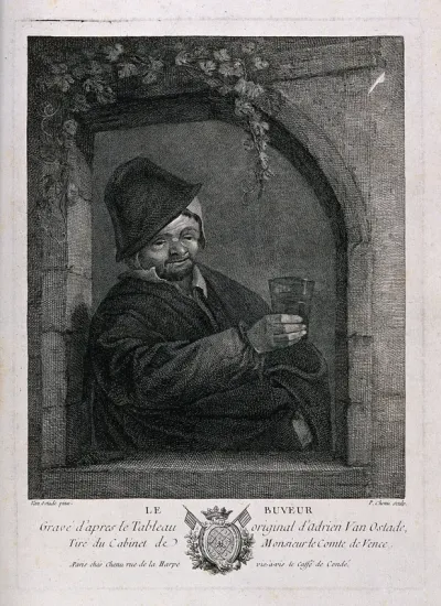 A man with glass in hand stands by a window